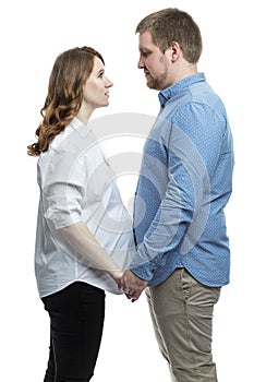 A young pregnant woman and a man are hugging. Happiness in anticipation of the baby by parents. Love and tenderness. White