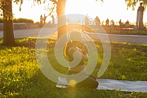 Young pregnant woman meditating in nature, practice yoga. Care of health and pregnancy