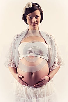 Young pregnant woman with naked belly smiling