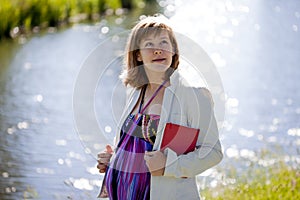 Young pregnant woman outdoors. Summer walk