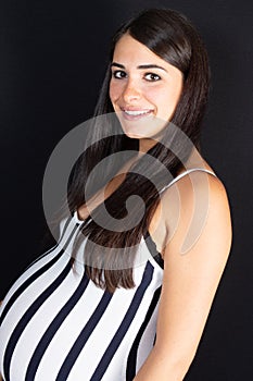 Young pregnant woman portrait holding her stomach smiling