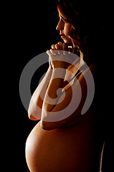 Young pregnant woman praying