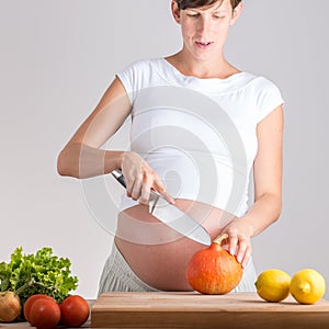 Young pregnant woman preparing vegetables