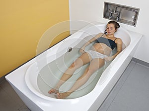 Young pregnant woman relaxing in birthing pool