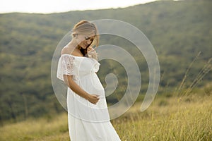 Young pregnant woman relaxing outside in nature