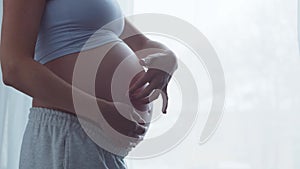 Young pregnant woman is resting at home and expecting a baby. The concept of pregnancy, motherhood, health and lifestyle