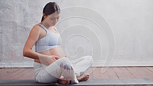 Young pregnant woman is resting at home and expecting a baby. The concept of pregnancy, motherhood, health and lifestyle