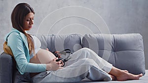 Young pregnant woman is resting at home and expecting a baby. The concept of pregnancy, motherhood, health and lifestyle