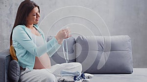 Young pregnant woman is resting at home and expecting a baby. The concept of pregnancy, motherhood, health and lifestyle