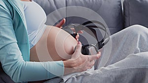 Young pregnant woman is resting at home and expecting a baby. The concept of pregnancy, motherhood, health and lifestyle