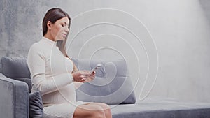 Young pregnant woman is resting at home and expecting a baby. The concept of pregnancy, motherhood, health and lifestyle