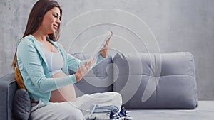 Young pregnant woman is resting at home and expecting a baby. The concept of pregnancy, motherhood, health and lifestyle