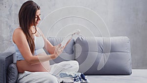 Young pregnant woman is resting at home and expecting a baby. The concept of pregnancy, motherhood, health and lifestyle