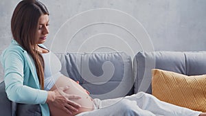 Young pregnant woman is resting at home and expecting a baby. The concept of pregnancy, motherhood, health and lifestyle