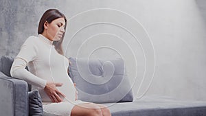 Young pregnant woman is resting at home and expecting a baby. The concept of pregnancy, motherhood, health and lifestyle