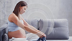 Young pregnant woman is resting at home and expecting a baby. The concept of pregnancy, motherhood, health and lifestyle