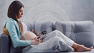 Young pregnant woman is resting at home and expecting a baby. The concept of pregnancy, motherhood, health and lifestyle