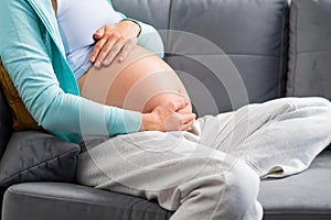 Young pregnant woman is resting at home and expecting a baby. Pregnancy, motherhood, health care and lifestyle concept.