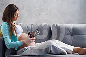 Young pregnant woman is resting at home and expecting a baby. Pregnancy, motherhood, health care and lifestyle concept.