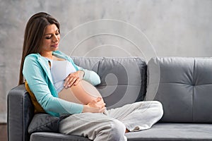 Young pregnant woman is resting at home and expecting a baby. Pregnancy, motherhood, health care and lifestyle concept.