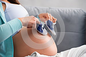 Young pregnant woman is resting at home and expecting a baby. Pregnancy, motherhood, health care and lifestyle concept.