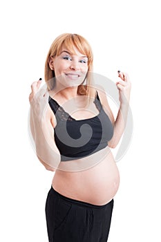 Young pregnant woman showing good luck symbol crossing fingers