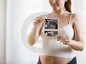 Young Pregnant Woman Showing Medical Baby Scans