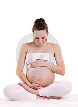 Young pregnant woman sitting in a lotus position