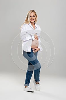 Young pregnant woman in studio. Beautiful stomach. Pregnancy, childbearding and new life concept.