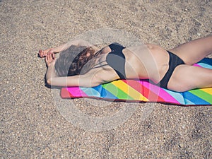 Young pregnant woman sunbathing on beach