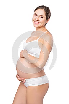 Young pregnant woman in swimsuit. Girl expecting a baby and touching her belly isolated on white background.