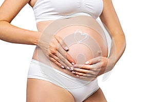 Young pregnant woman in swimsuit. Girl expecting a baby and touching her belly isolated on white background. Close-up