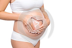 Young pregnant woman in swimsuit. Girl expecting a baby and touching her belly isolated on white background. Close-up