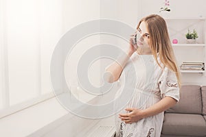 Young pregnant woman talking on her smartphone