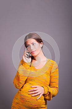 Young pregnant woman talking on mobile phone