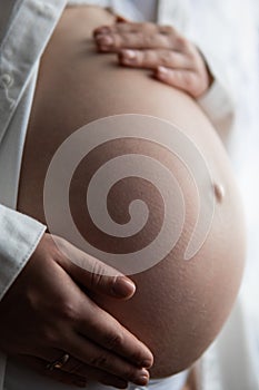 Young pregnant woman touching her belly, pregnant woman with her hands on her back  on white background.