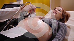 Young pregnant woman on ultrasound scan in clinic