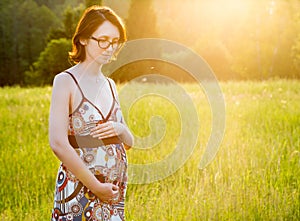 Young Pregnant Woman Walking in the Park