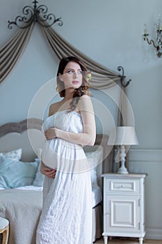 Young pregnant woman in white dress