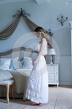 Young pregnant woman in white dress