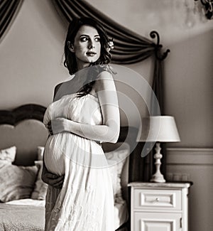 Young pregnant woman in white dress