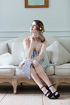 Young pregnant woman in white dress sitting