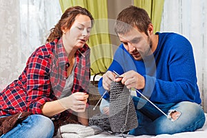 Woman is teaching knit a young man