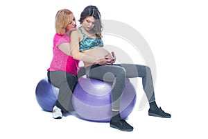 Young pregnant woman exercising with physiotherapist in birthing school. Doctor`s help conceptat in antenatal class