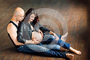 Young pregnant women with her husband in studio
