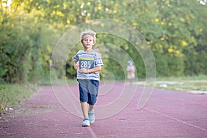 Young preschool children, running on track in a marathon competition