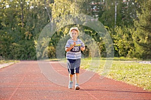 Young preschool children, running on track in a marathon competition