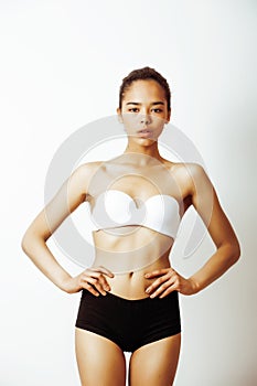 Young pretty african american girl in sport underwear posing on white background, very slim loosing weight mulatto half