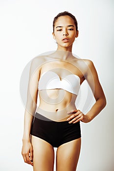 Young pretty african american girl in sport underwear posing on white background, very slim loosing weight mulatto half