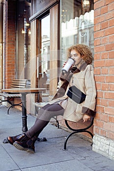 Young pretty african american women drinking coffee outside in cafe, modern business woman lifestyle concept